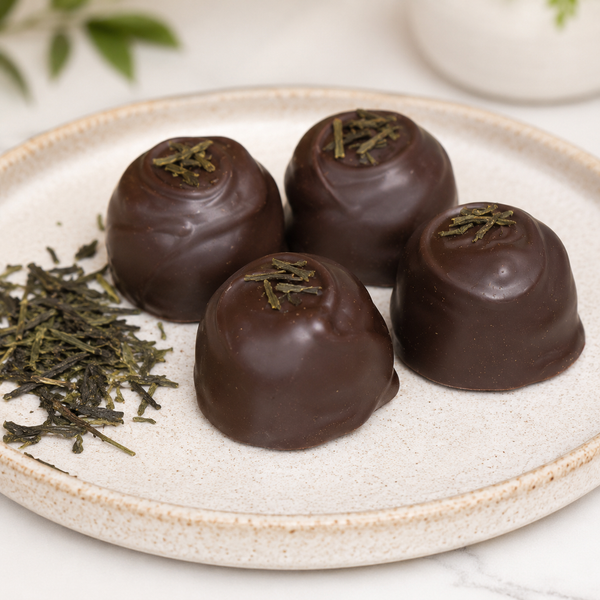 Chocolate truffles with tea leaves on a white plate